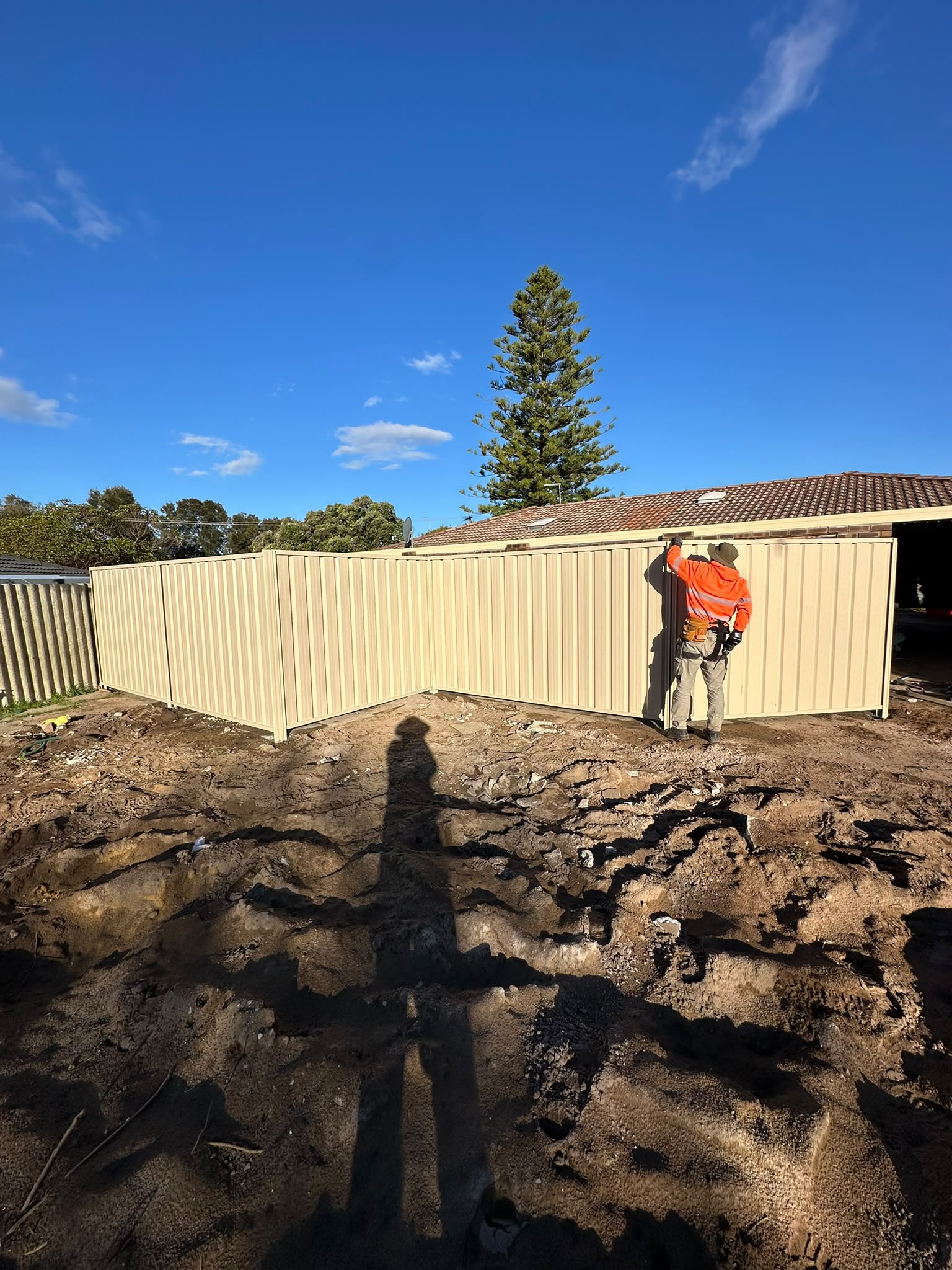 Cream Colorbond boundary fence being installed