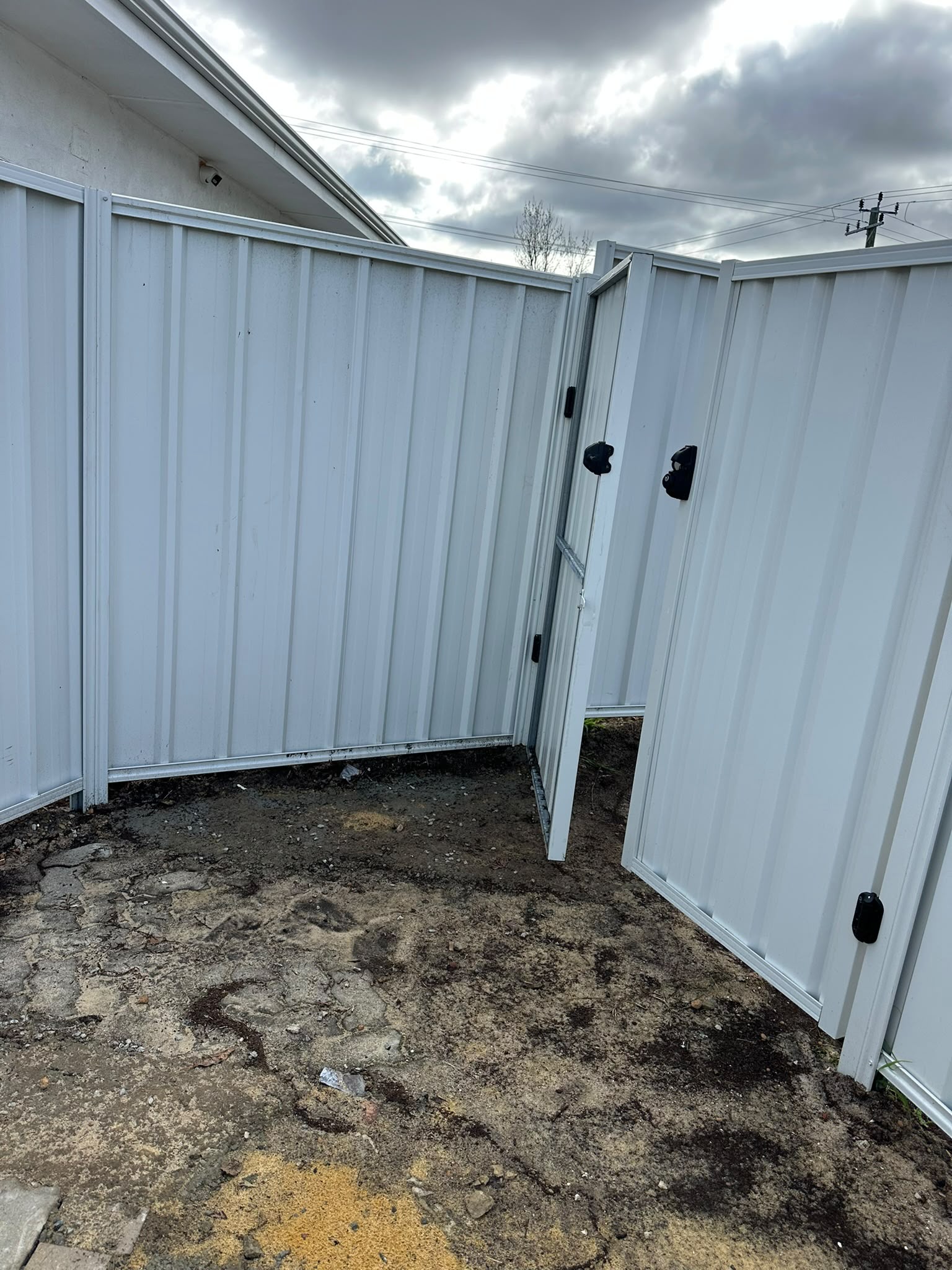 White Colorbond pedestrian gates within a new fence line